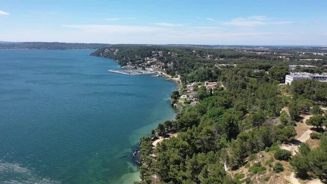 Aerial view drone video flying from the air over the picturesque sea coast of the south of France, Provence, Istres at bright sunny summer day