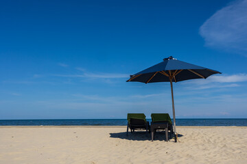 Blue umbrella and chair around beach sea ocean with blue sky for travel vacation