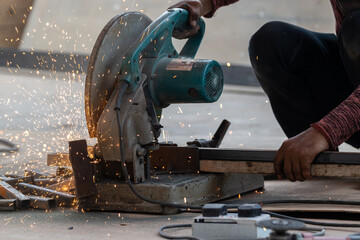 Man use saw cutting machine to cut metal tube