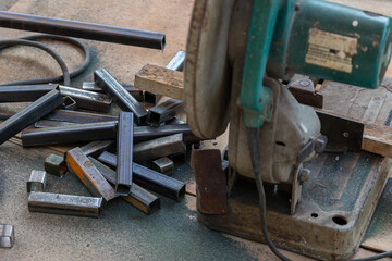 Man use saw cutting machine to cut metal tube