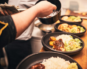 Chef, plate and hands in kitchen with healthy food, dish and preparation on table in hospitality service. Professional meal prep, person and cooking at diner for order, dining and culinary experience