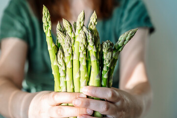 Asparagus. Vegan girl holding fresh asparagus. Juicy healthy farm asparagus, eco agriculture...