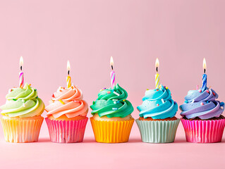 Five colorful cupcakes with candles on a pink background, ideal for birthday celebrations and copy space