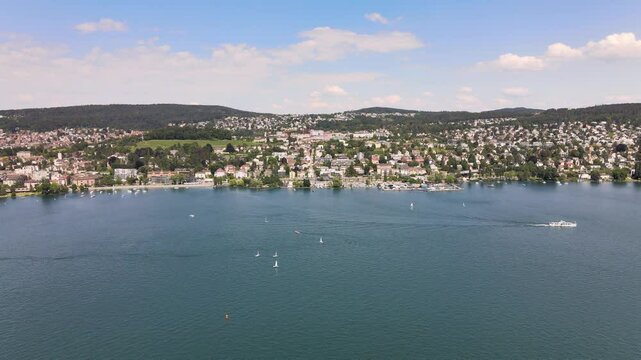 Drone flyover shot over Lake Z&uuml;rich in Switzerland towards Zollikon
