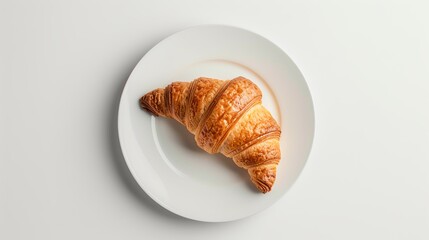 A minimalist shot featuring a single, perfectly baked croissant on a white plate, set on a clean surface with ample copy space