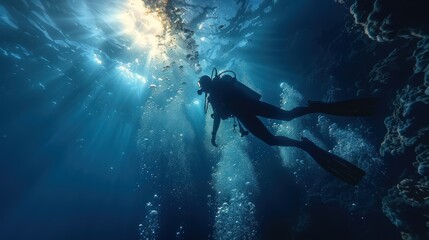 Scuba Diver Ascending Towards Sunlight in Deep Blue Water