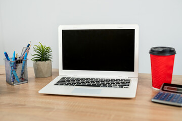 Fototapeta premium Empty notepad with pen laptop calculator coffee on a office wooden surface, nobody.