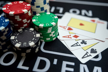 Four Ace playing cards with chips on casino table