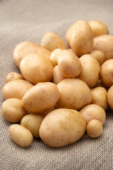 Clean, washed potatoes lie in a stack on the jute.