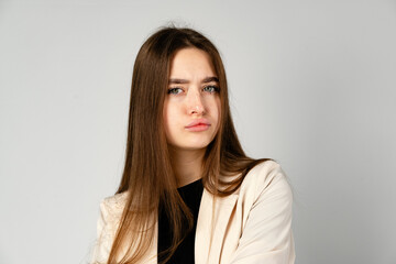Young Woman in White Jacket and Black Pants on Gray Background.