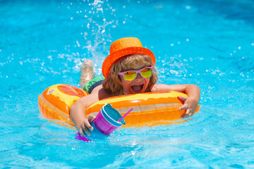 Boy kid swimming and playing in a pool. Child playing in swim pool. Summer vacation concept. Summer fashion kids portrait.