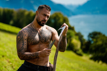 Sexy Man in grass farm on countryside. Sexy Farmer with bare naked torso. Muscular sexy farm worker in the farm field. Strong shirtless Farmer on rural farm. Male farmer at his land. Handsome cowboy