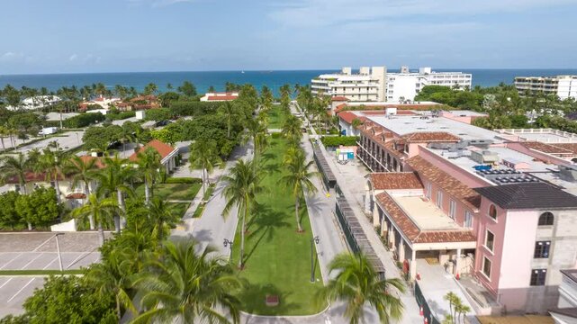 West Palm Beach ocean and Royal Palm Way. Aerial reverse dolly hyper lapse over wealthy neighborhood and street with beach front access. Beautiful Florida city, time lapse.
