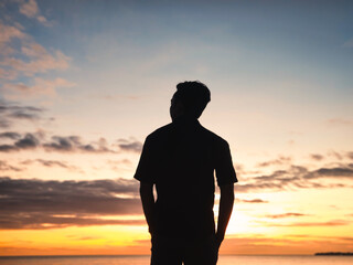 Silhouette photo of a man enjoying the sunset on the beach after coming home from work