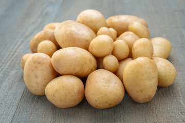 A pile of young beautiful fresh potatoes on a gray wooden background. Close-up.