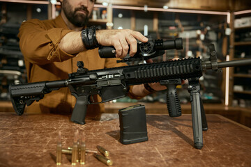 Salesman in process of tactical firearms assembly, quality guns demonstration