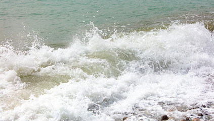 Sea waves on a pebble beach as a background