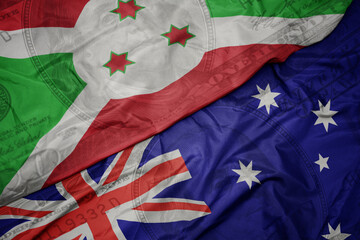 waving colorful flag of burundi and national flag of australia on the dollar money background. finance concept.