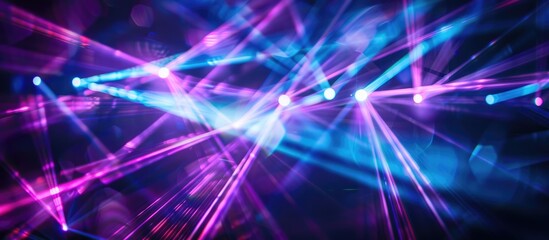 Bright laser light in shades of blue and violet illuminating a dark backdrop