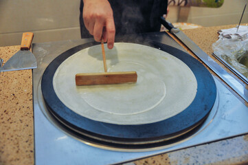 Making pancake rolled with crisp fritter, traditional Chinese food, street snacks,