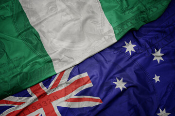 waving colorful flag of nigeria and national flag of australia on the dollar money background. finance concept.