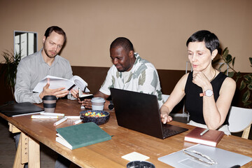 Minimal shot of business meeting with diverse group of people using computer and discussing project...