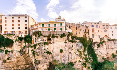 Obraz premium scenic travel landscape of beautiful historic town Tropea in Italy with old antique buildings, vintage houses on a high rock cliff above sea and amazing blue sky on background