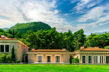 green garden landscape of beautiful resort with three nice buildings with windows, pool with water and green trees on background