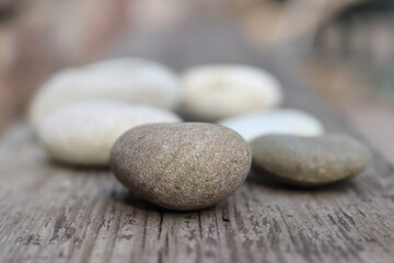 Beautiful round stones lie on a wooden floor, close-up, blurred background.