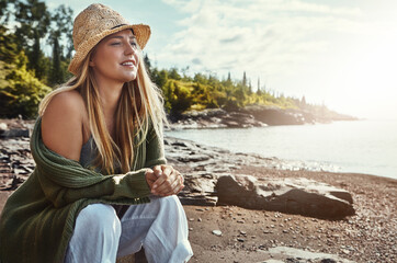 Thinking, relax and woman at beach with hat, outdoor holiday and calm nature on tropical island. Travel, peace and girl on ocean vacation with water, trees and morning inspiration on coast in Sweden