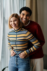 A happy interracial couple smiles and enjoys quality time together in their modern apartment.