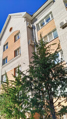 Multi-story residential building. Sale rental apartments. Housing development. City life. Real estate. Mortgage concept. Condos. Interest Rate. Flat. Green tree. Air conditioner on brick wall.