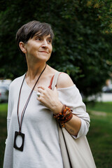 Portrait of stylish grey haired woman with handbag standing on urban street