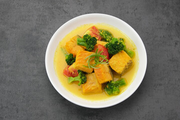 Salmon Kuah Kuning, fish soup with broccoli and tomatoes. Indonesian food
