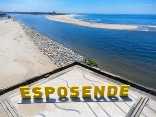 Esposende / Portugal - May 9, 2024: Big yellow block letters spelling Esposende offer tourists a selfie-photo opportunity with a beautiful blue sea in the background. 