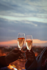 romantic date in restaurant, hands closeup couple drinking champagne with night city lights background