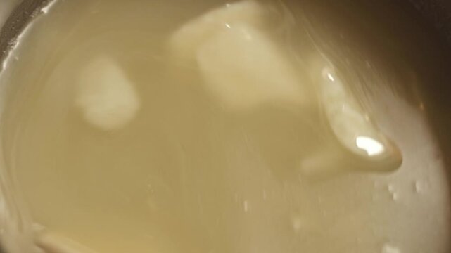 Person mixes the soap mass in the process of making soap. The master mixes the ingredients in the workshop