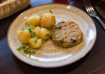chicken burger with boiled potatoes on plate
