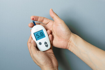 hand of people check diabetes and high blood glucose monitor with digital pressure gauge. Healthcare and Medical concept	