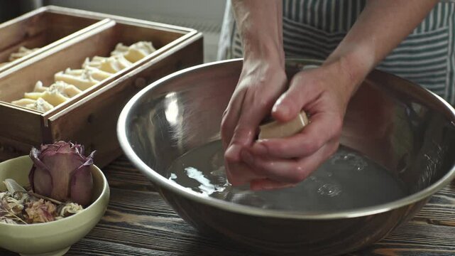 A woman washes her hands with handmade natural soap. Hygiene and gentle skin care