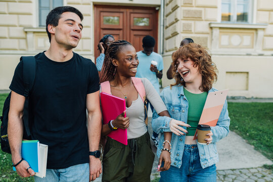 Diverse college students going on a break after lectures and smiling.