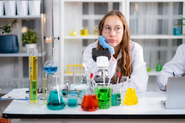 Young White Scienctist woman sitting at experiment work desk with boring emotion, experiment in Lab room.