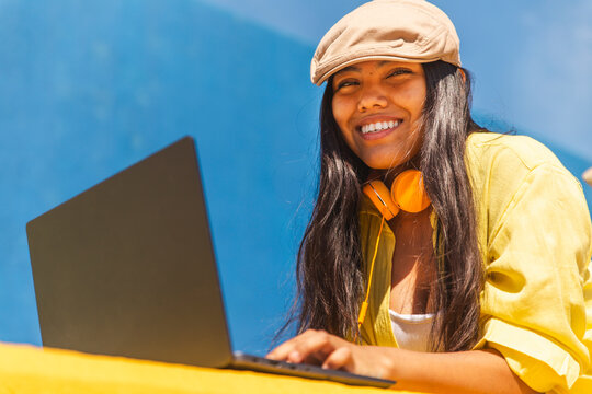 Smiling young freelancer with laptop on sunny day