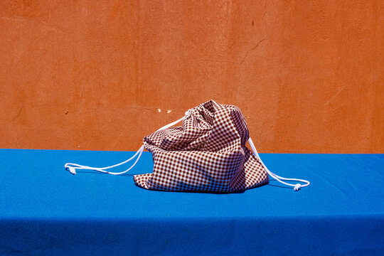 Red check fabric cloth drawstring bag kept on table