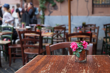 flower on wooden table in restaurant terrace in Trastevere, Rome, Italy