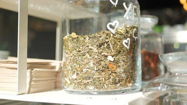 A detailed view of various jars filled with herbs and spices in a warm kitchen or cafe atmosphere
