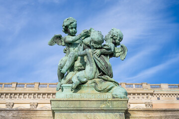 Statues with a verdigris patina stand against the clear blue sky at the Stockholm Royal Palace in Sweden, showcasing intricate artwork and historic architecture.