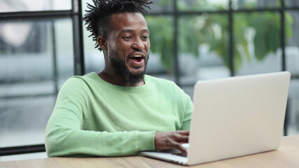 Close-up of a laughing african american man looking into a laptop