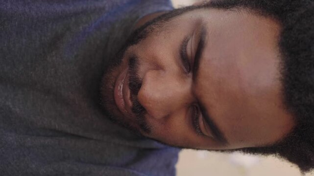 Vertical shot of young African man sad and heartbroken after argument with frien
