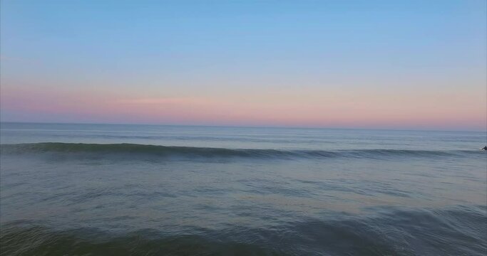 Calm ocean waves crashing on a beach at sunset in Cape Cod, Massachusetts, United States of America.